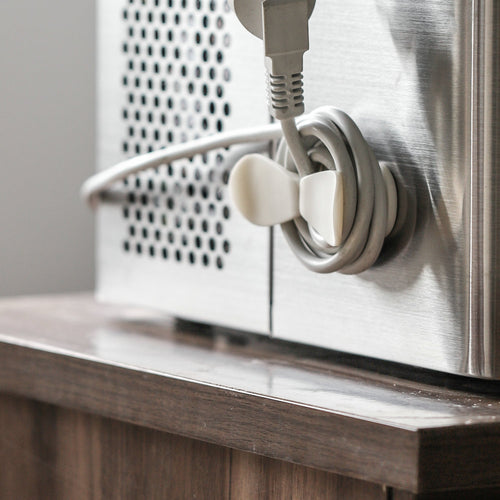 Stick-on cord winder on a toaster